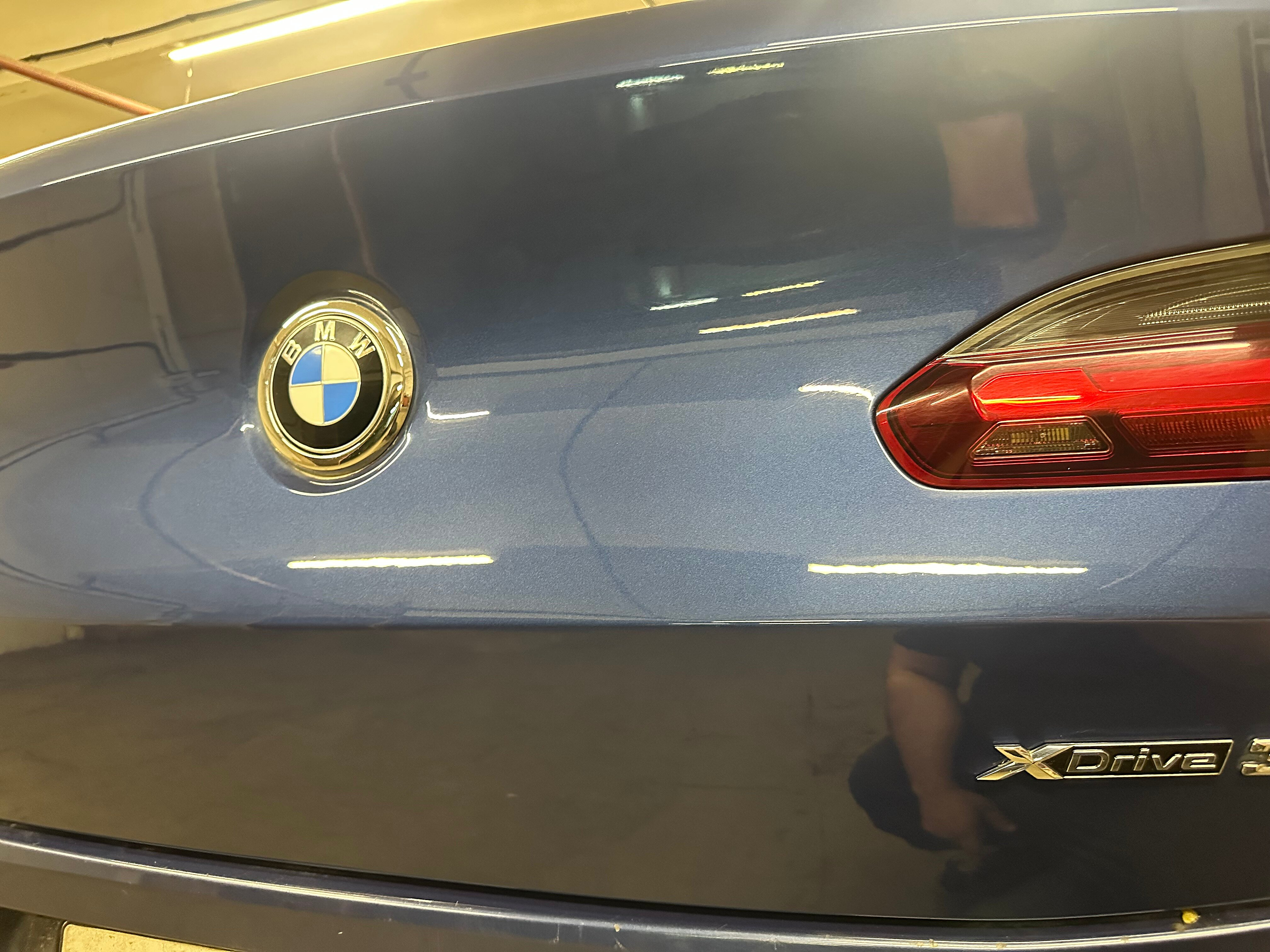 Голубая крышка багажника BMW с отражением инспекционного света